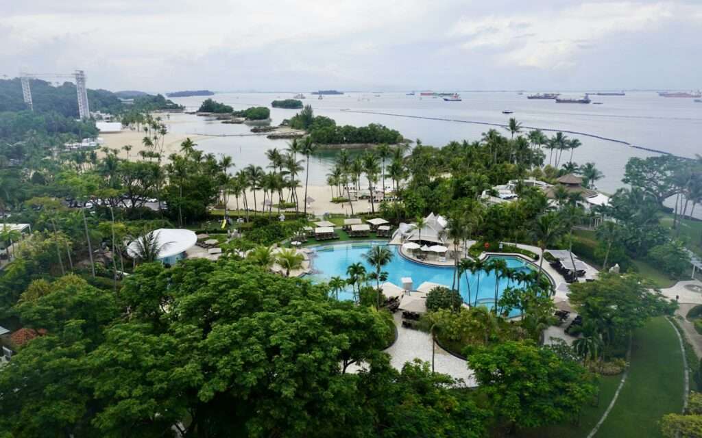Aerial view of Sentosa beach lagoons with cargo ships anchored offshore